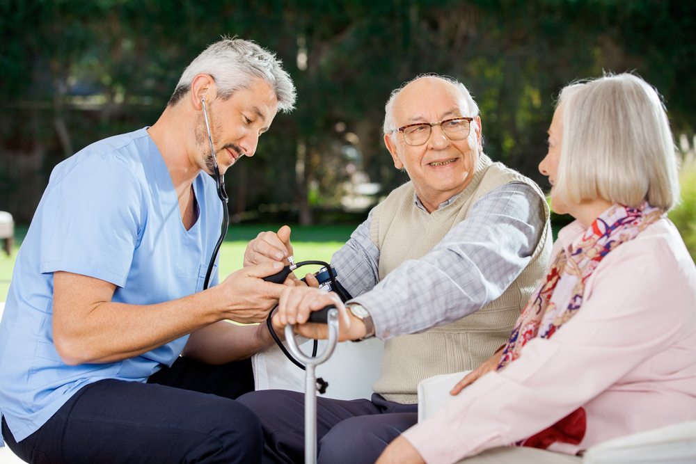 mid,adult,doctor,measuring,blood,pressure,of,senior,man,sitting